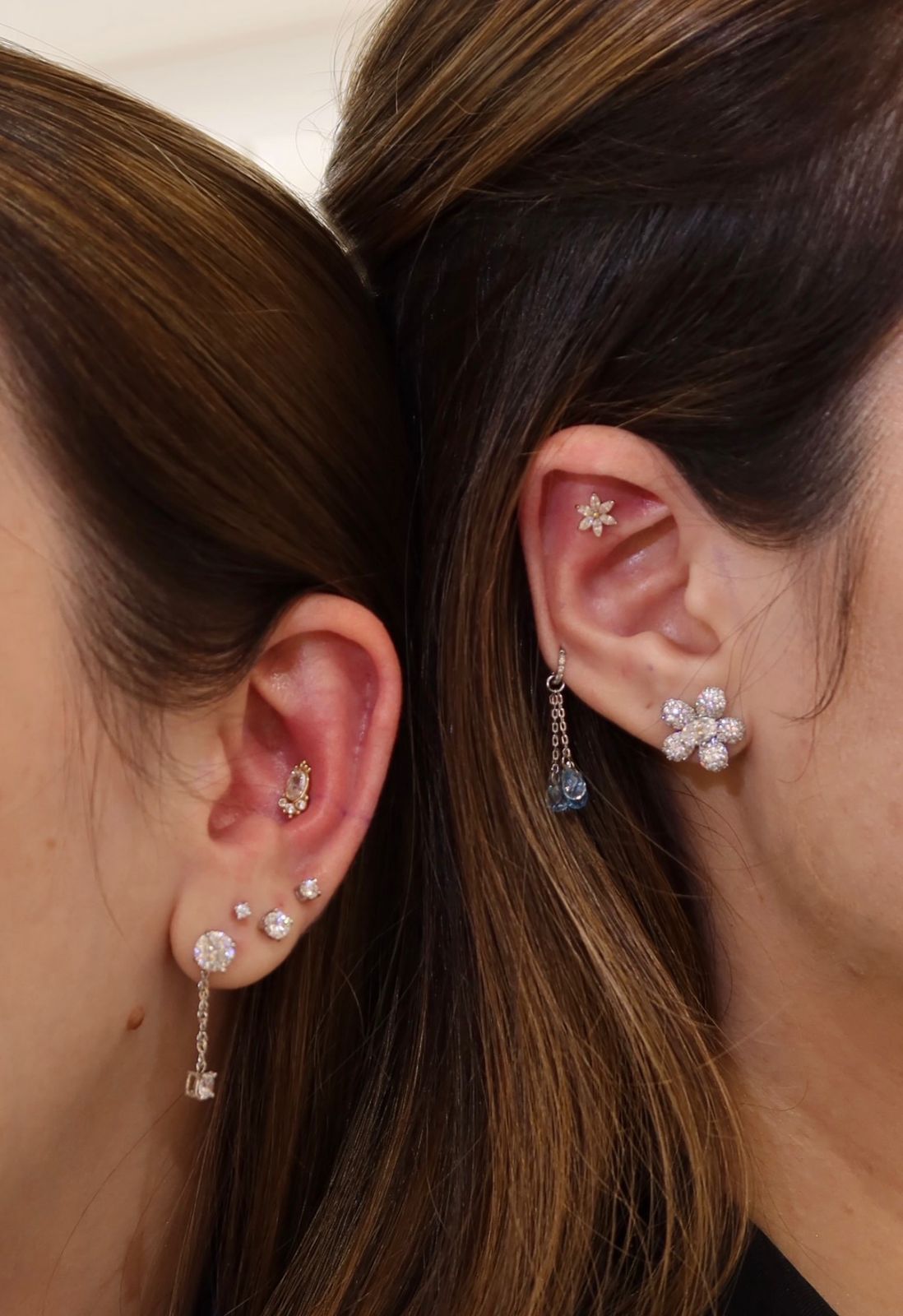 Duas orelhas com múltiplos piercings delicados, trabalho de body piercing na Maria Antonieta